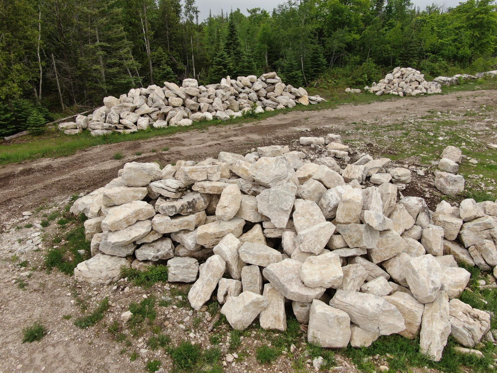 Multiple sorted piles of character limestone boulders