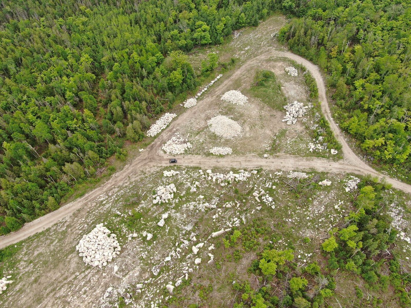 Aerial overview of sorted stone piles in the quarry yard