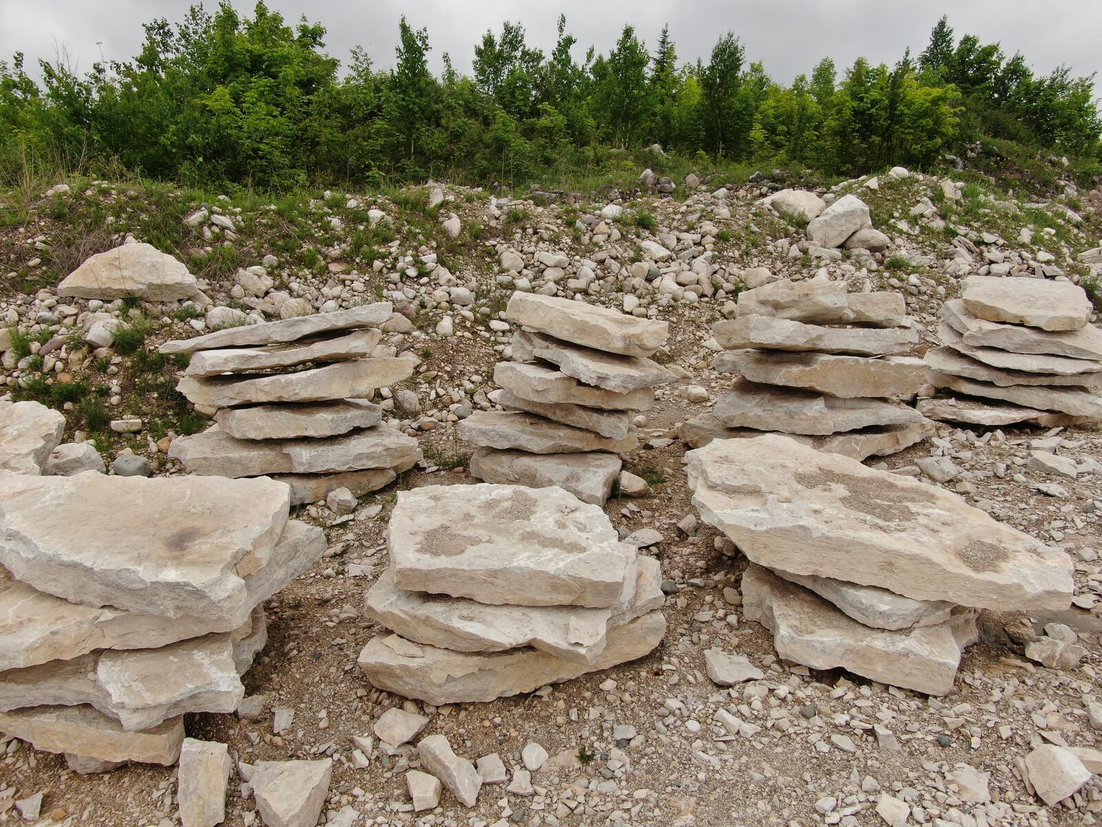 Multiple stacks of flat limestone flagstone ready for sale
